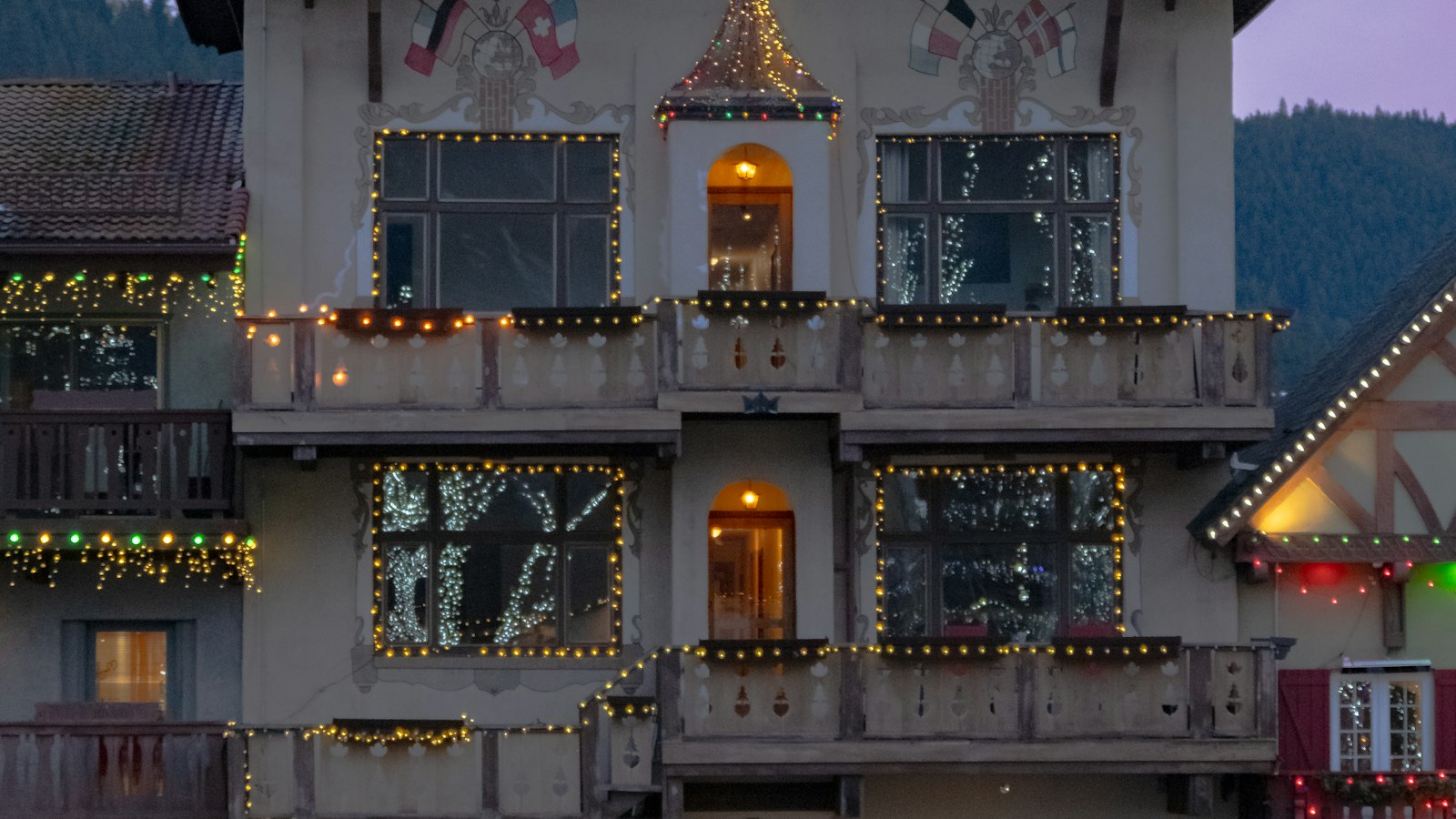 A Bavarian-style building in Leavenworth lit with Christmas lights at dusk