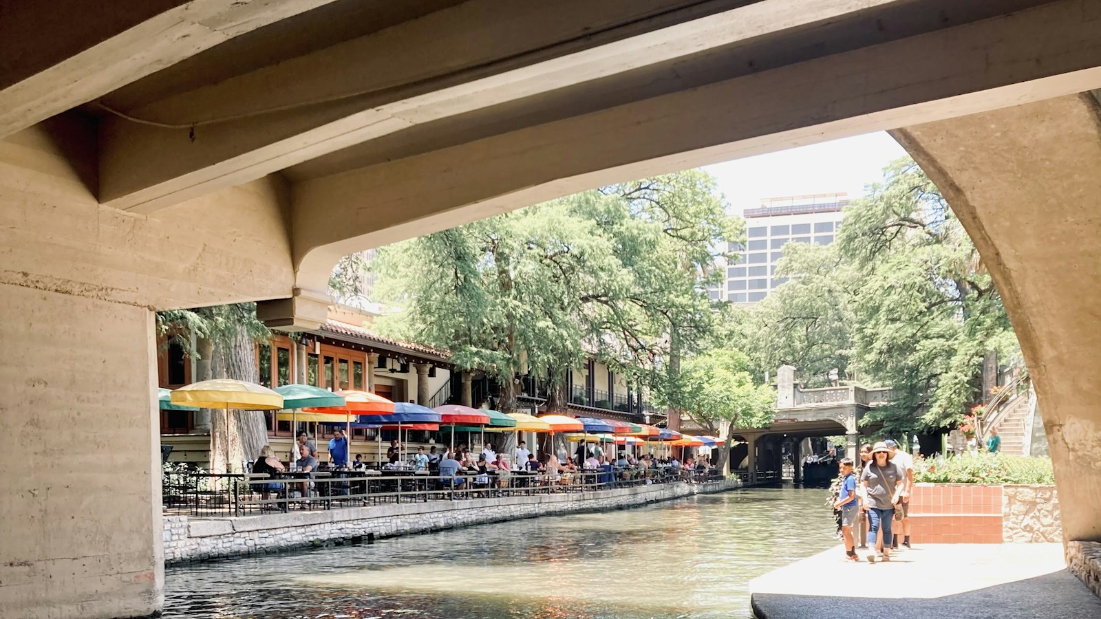 The San Antonio River Walk lined with restaurants and umbrellas
