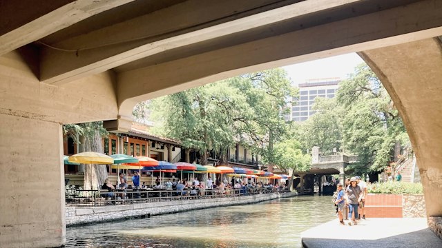 The San Antonio River Walk lined with restaurants and umbrellas