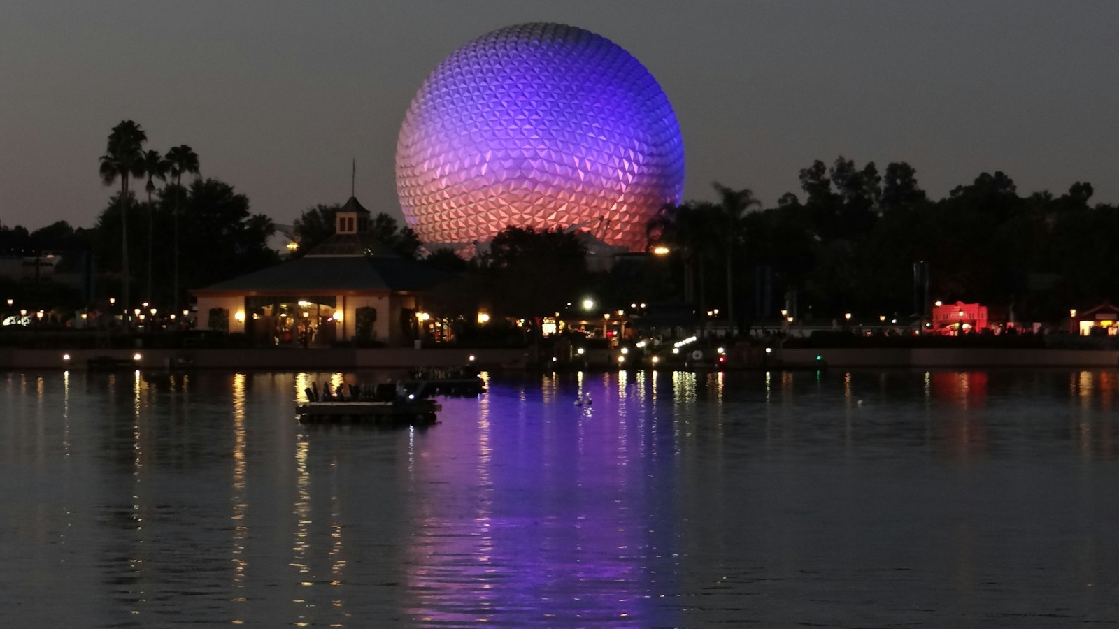 Epcot's Spaceship Earth lit in purple and orange at dusk