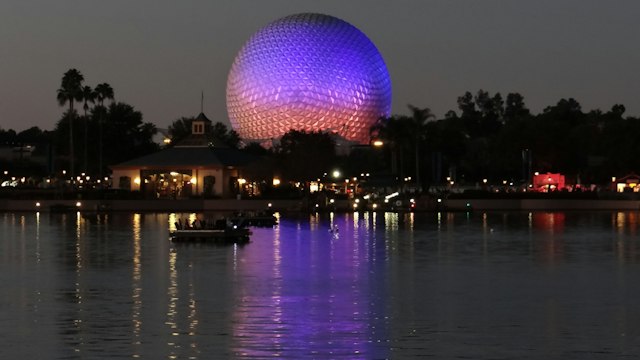 Epcot's Spaceship Earth lit in purple and orange at dusk